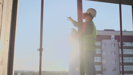 Engineer-the-Builder-on-the-roof-of-the-building-stands-in-VR-glasses-and-moves-his-hands-using-the-interface-of-the-future.-Futuristic-engineer-of-the-future.